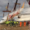 Stricken plane that came off the runway is lifted from slope